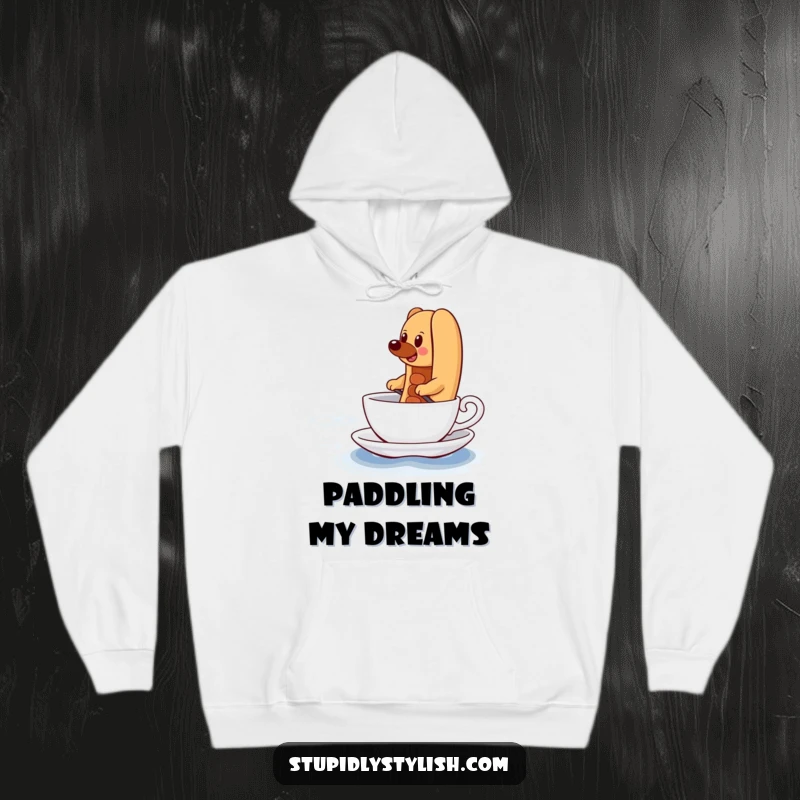 Funny Hoodie depicting a determined hot dog comically paddling a teacup across a vast ocean, symbolizing a challenging but rewarding journey.