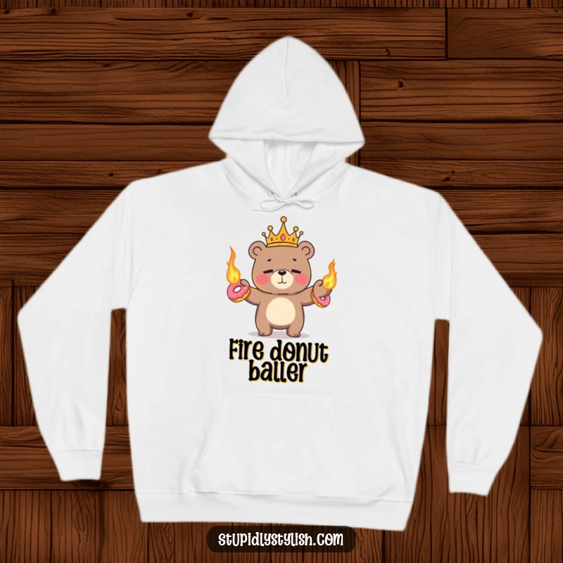 Funny, warm hoodie featuring a tiny crowned bear nervously juggling flaming donuts with a nervous smile.