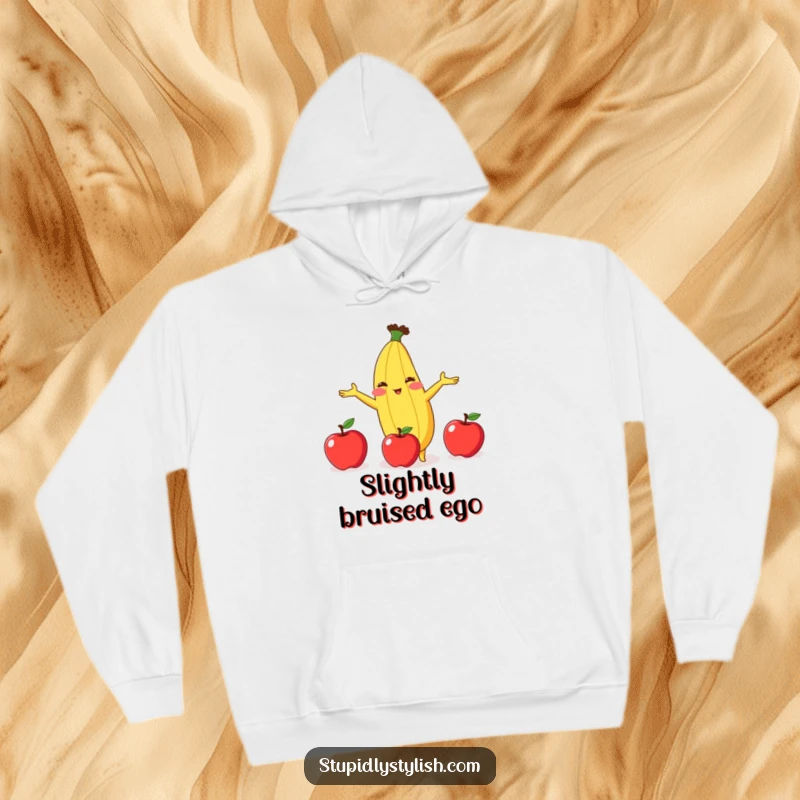 Funny hoodie featuring a red-faced anthropomorphic banana in a comical juggling act with three apples, looking slightly overwhelmed.