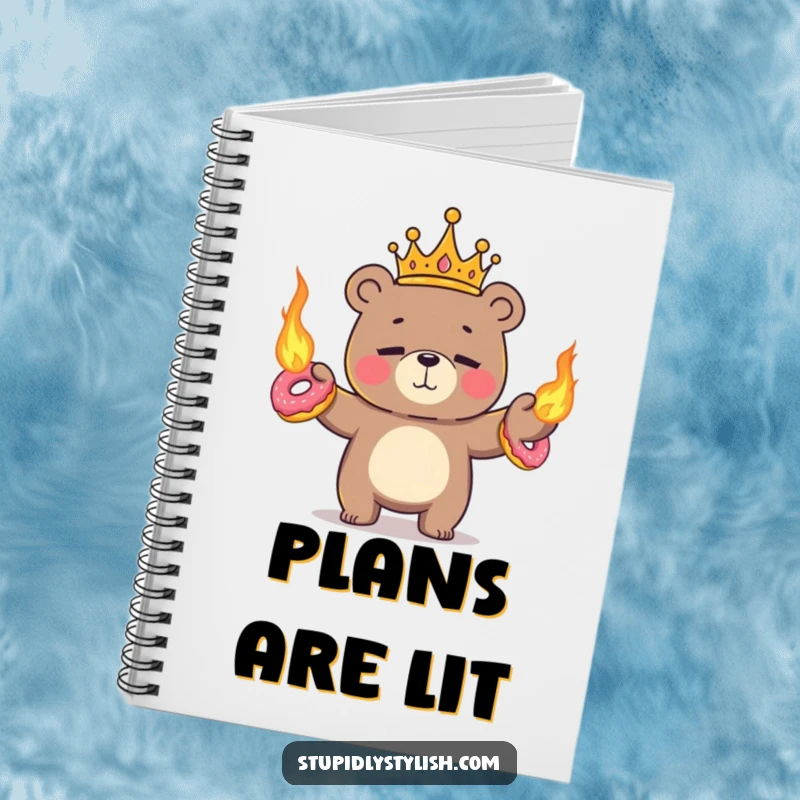 Funny, ruled notebook featuring a tiny crowned bear nervously juggling flaming donuts with a nervous smile.