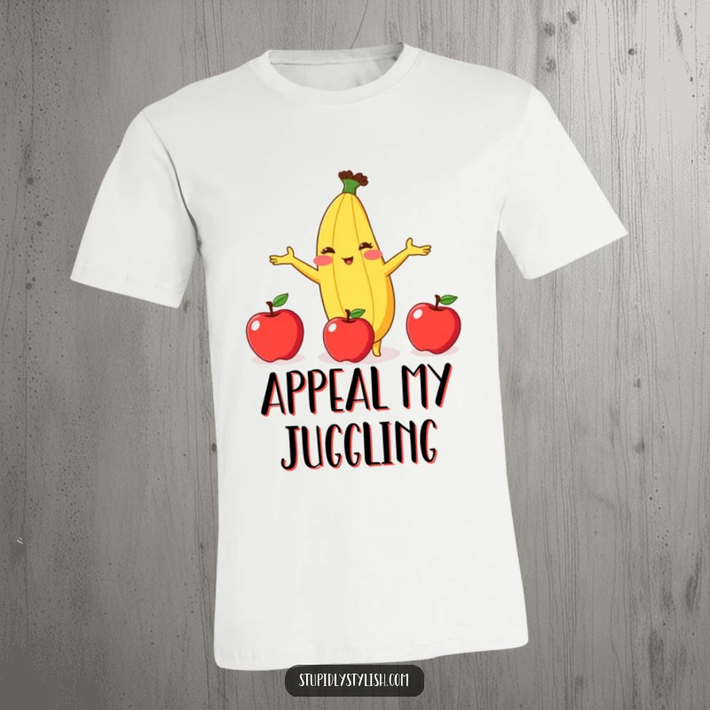 Funny t-shirt depicting a shy, blushing banana comically attempting to juggle three apples, showcasing a comical struggle.